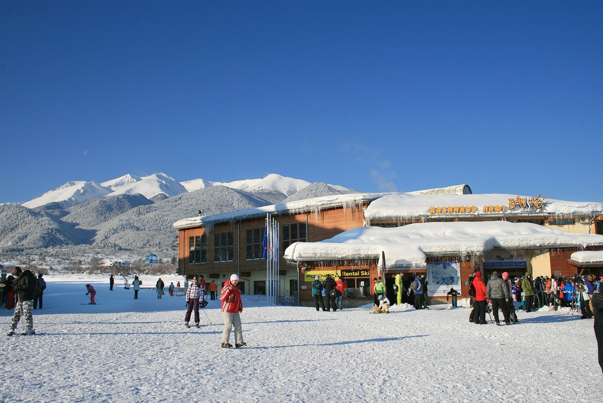 Snowy Bansko ski area with mountain views and skiers near the base