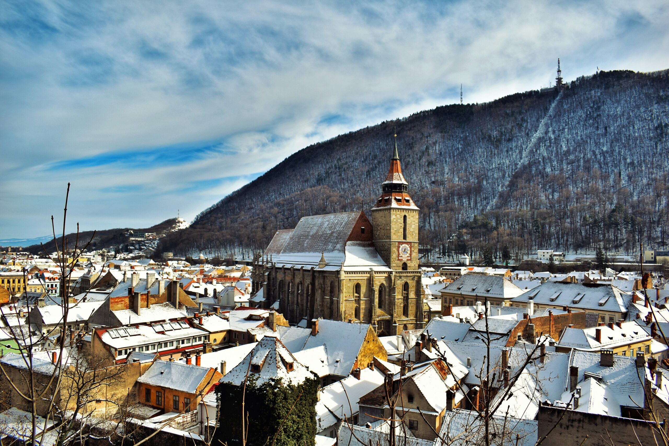 Historic buildings in Brasov, Romania, with mountain scenery
