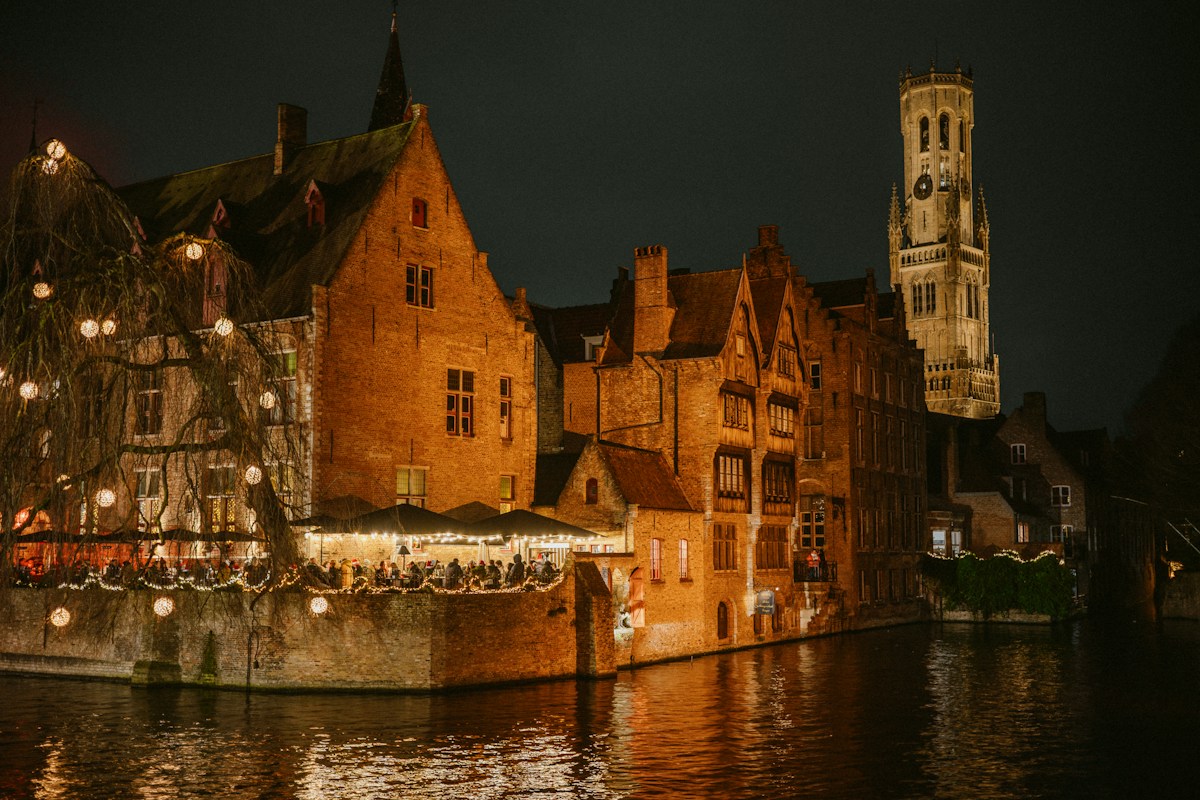 Historic buildings illuminated beside a canal in Bruges, Belgium