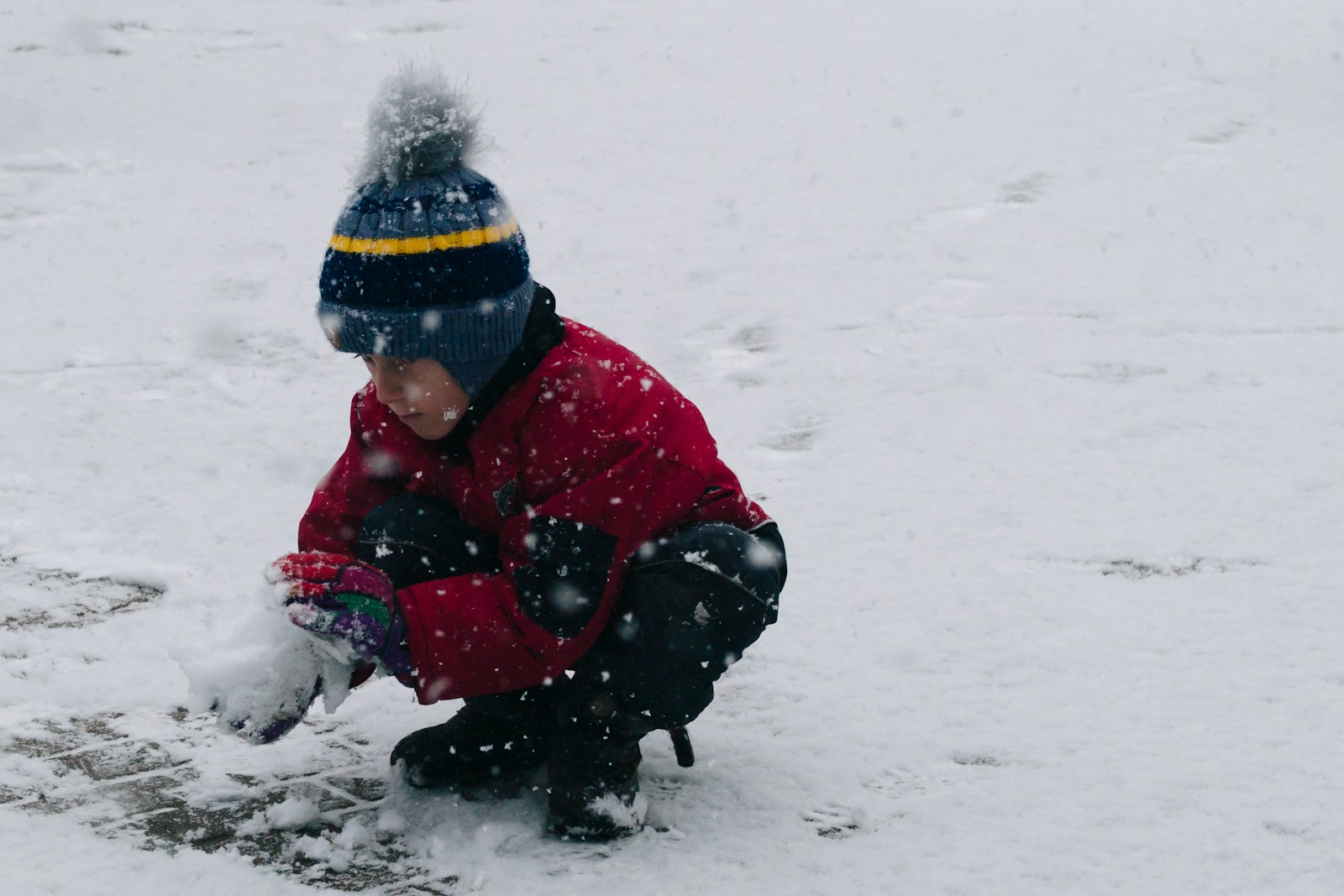 Child playing in fresh snow in winter