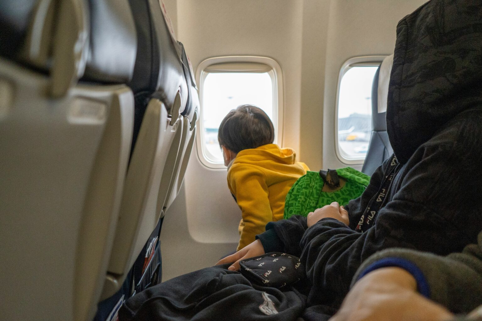 Young child seated on an airplane during a family flight
