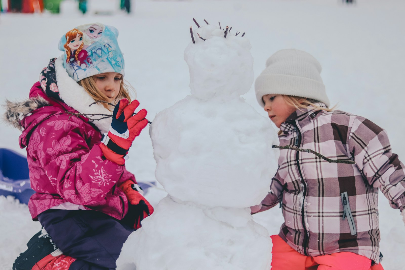 Children building a snowman outdoors in winter