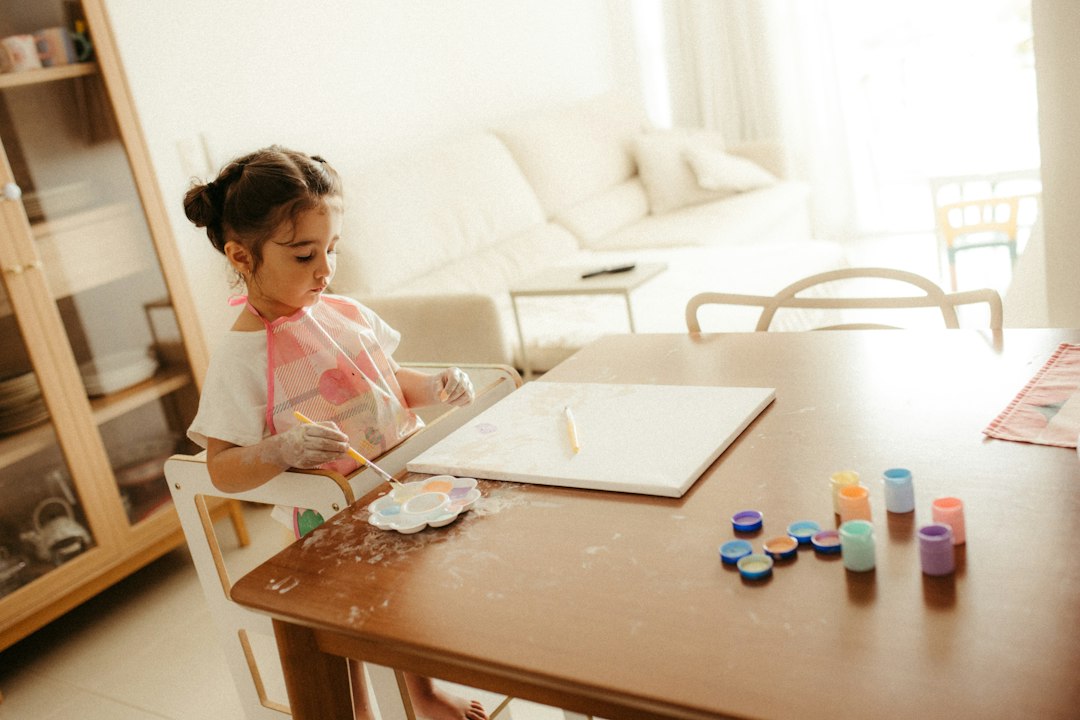 Child painting at a table with colorful art supplies