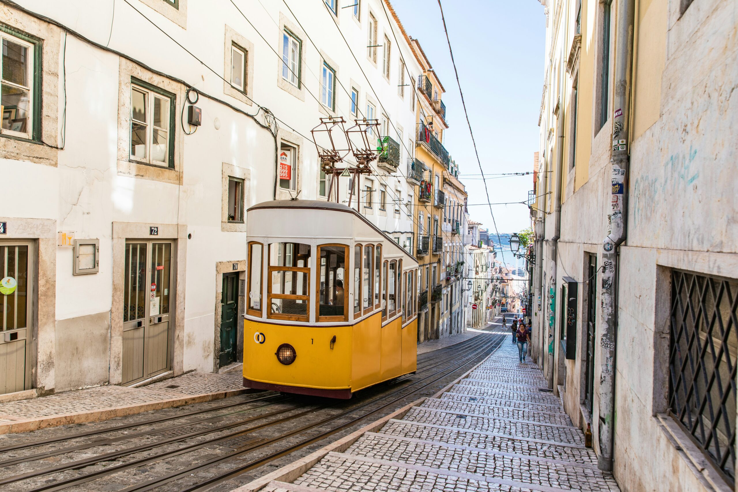Lisbon's historic yellow tram on a city street, illustrating family living in Portugal