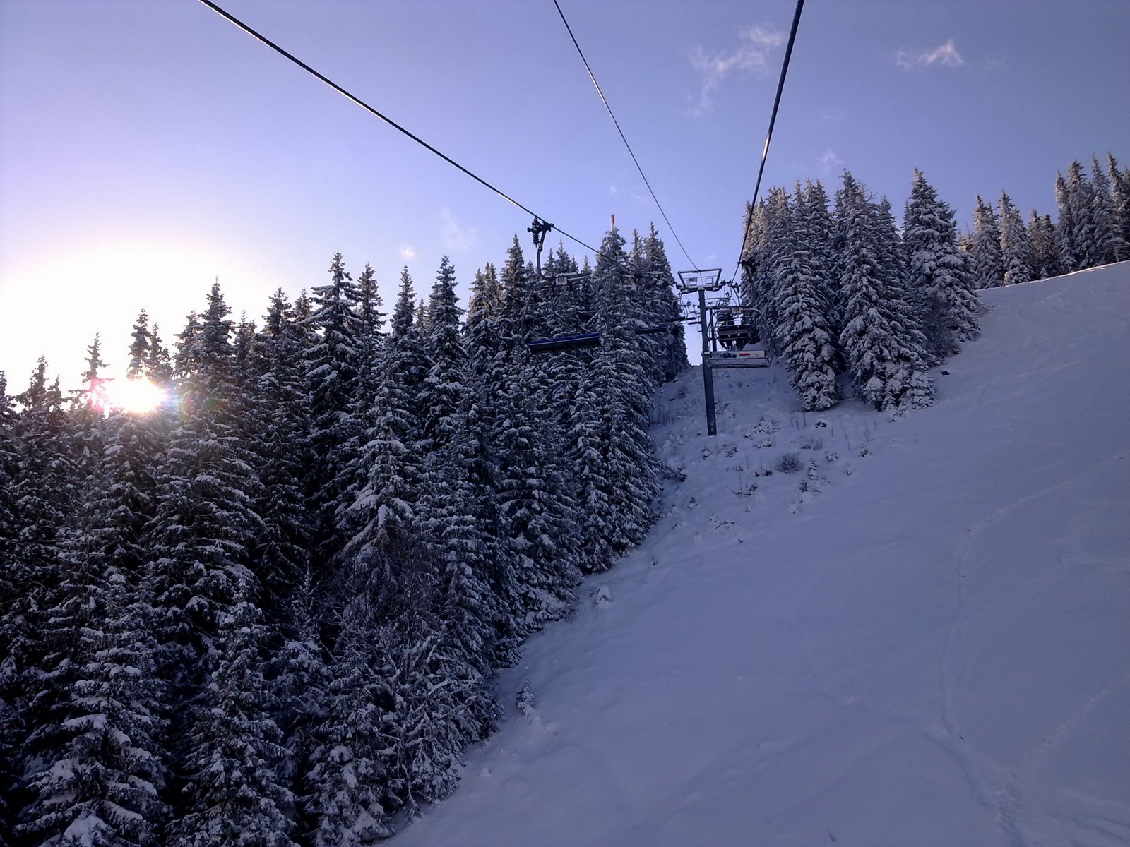 Ski lift running through snow-covered pine forest in Pamporovo, Bulgaria