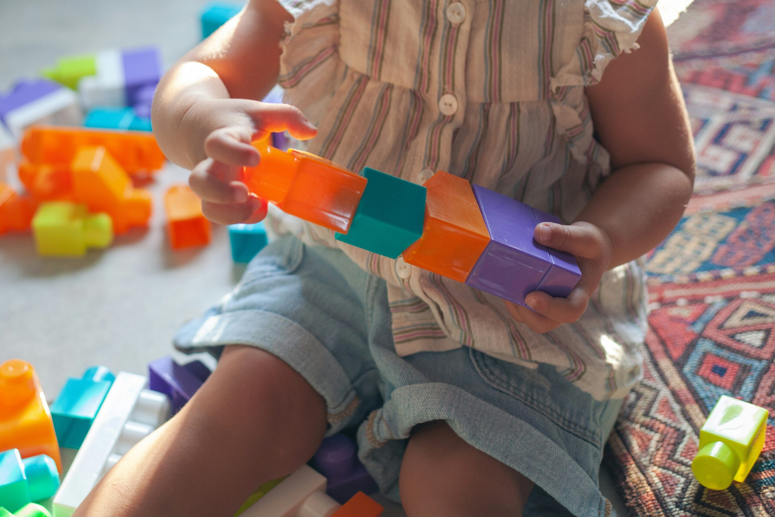Preschool child concentrating while stacking building blocks