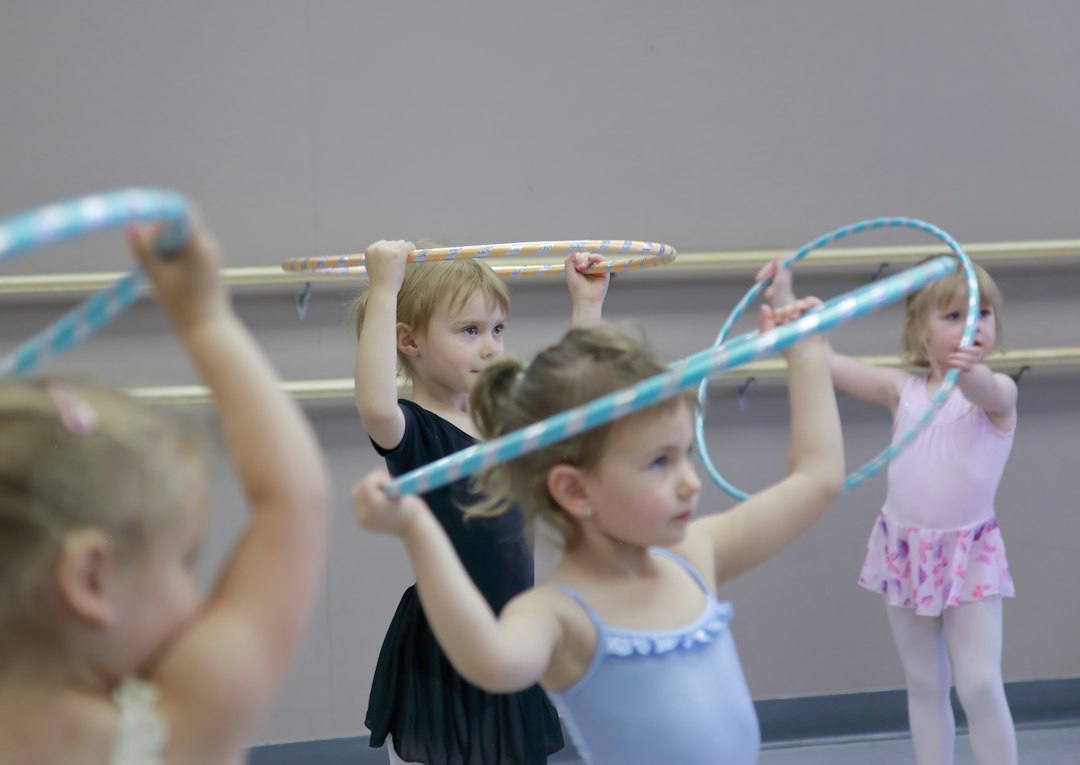 Young children dancing together indoors during an active listening and freeze dance game