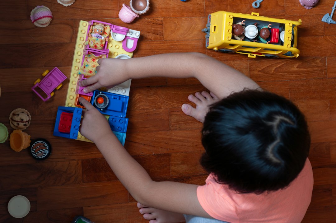 Young child arranging construction bricks and toy furniture during a problem-solving activity