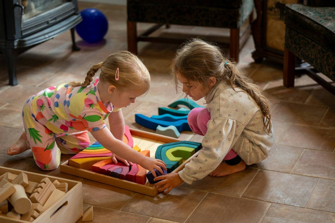 Preschool children concentrating as they build with colorful wooden blocks