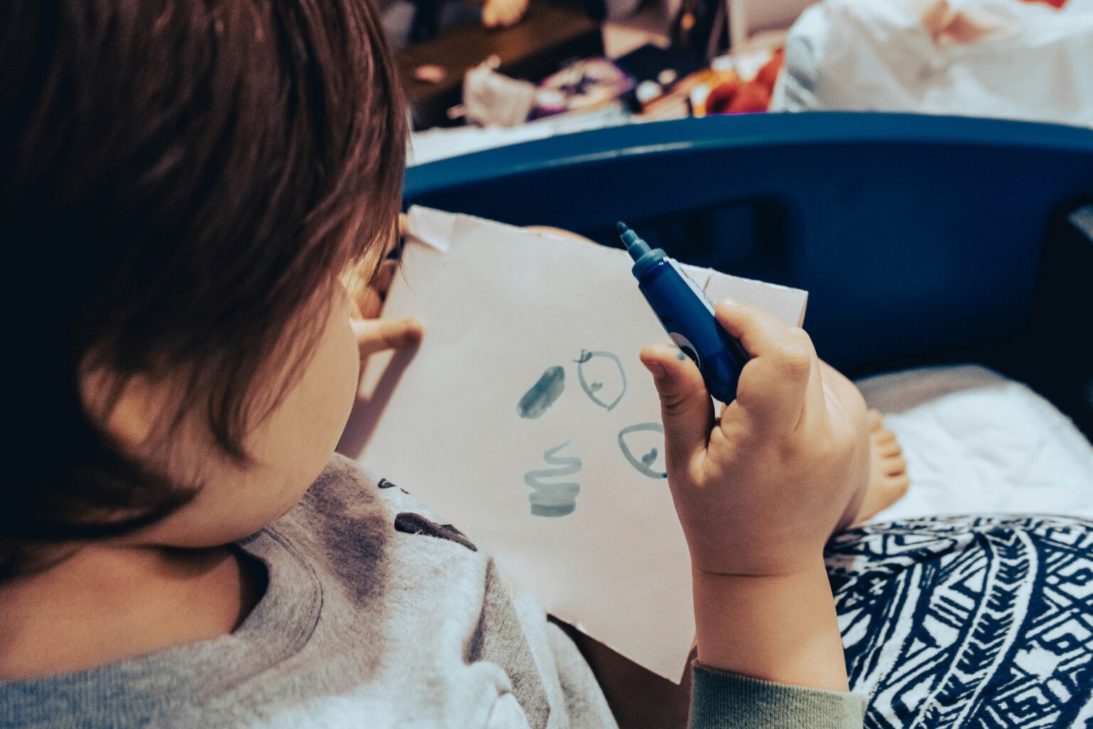 Child drawing on paper as an example of a quiet travel activity