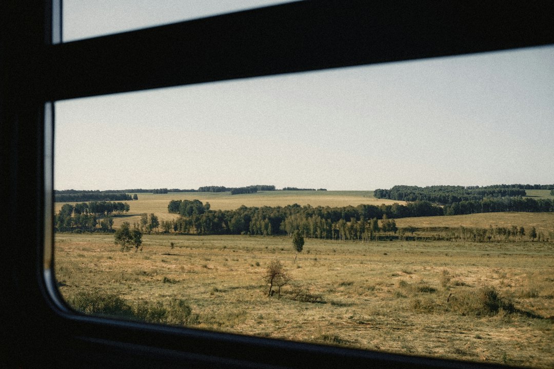 Open landscape viewed from a moving train during a rail journey