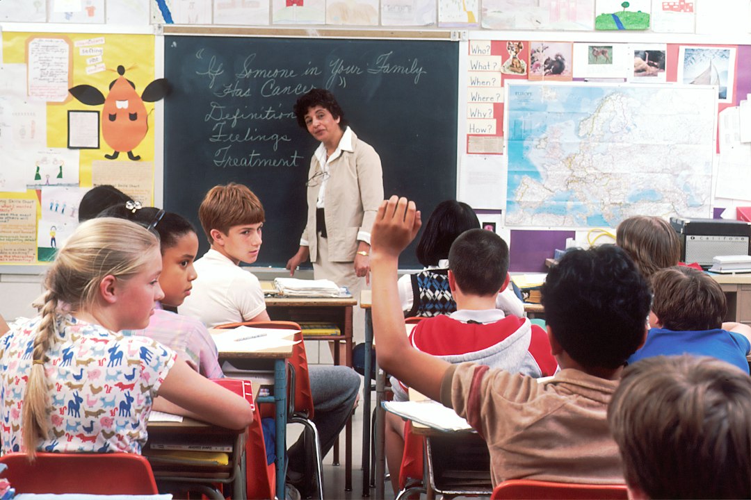 Children learning in a classroom with a teacher, illustrating questions to ask when visiting international schools in Bali