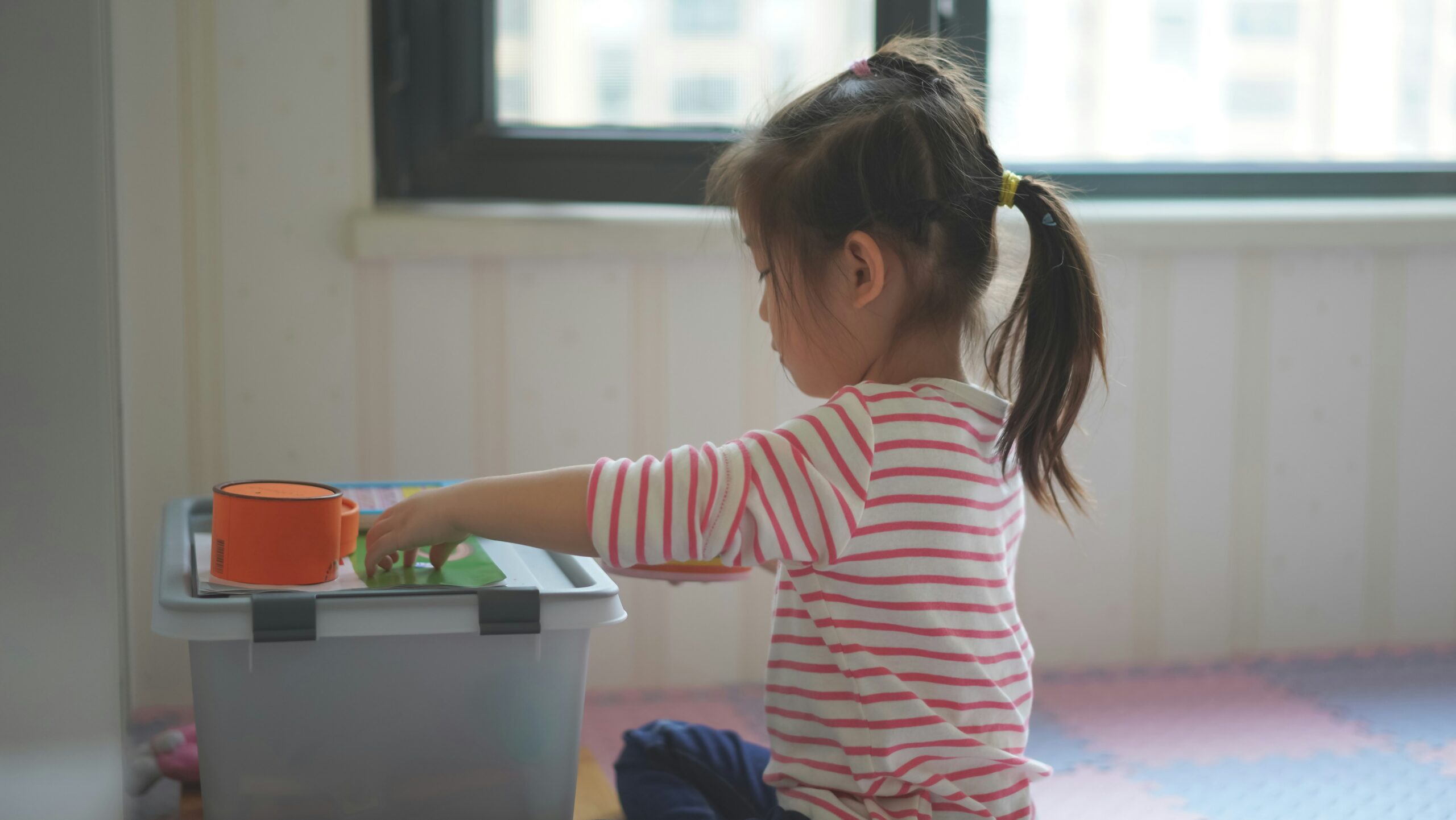 Toddler sitting on the floor exploring a hands-on play activity
